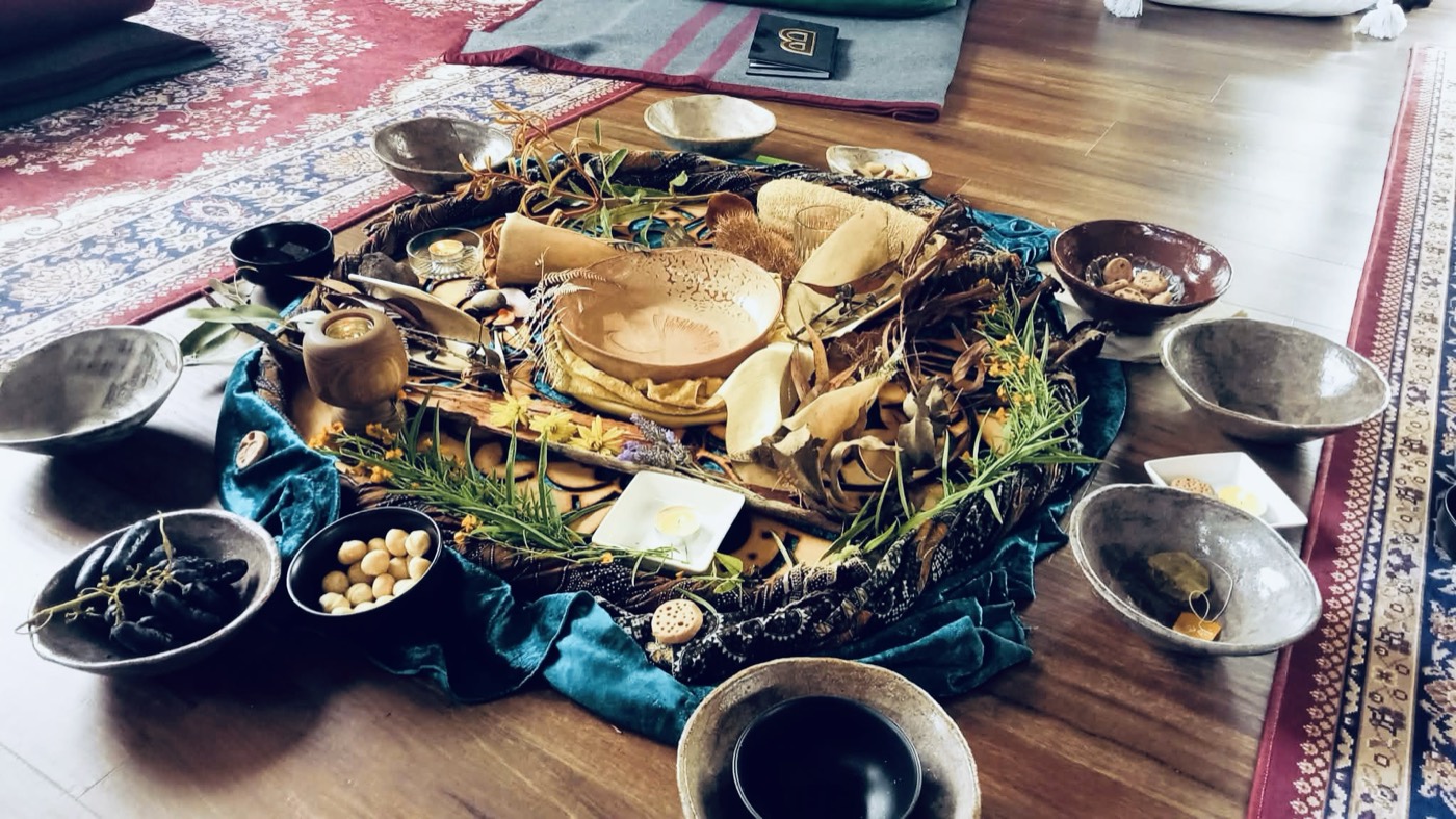An altar laid out with bowls, feathers and cloth for a women's circle