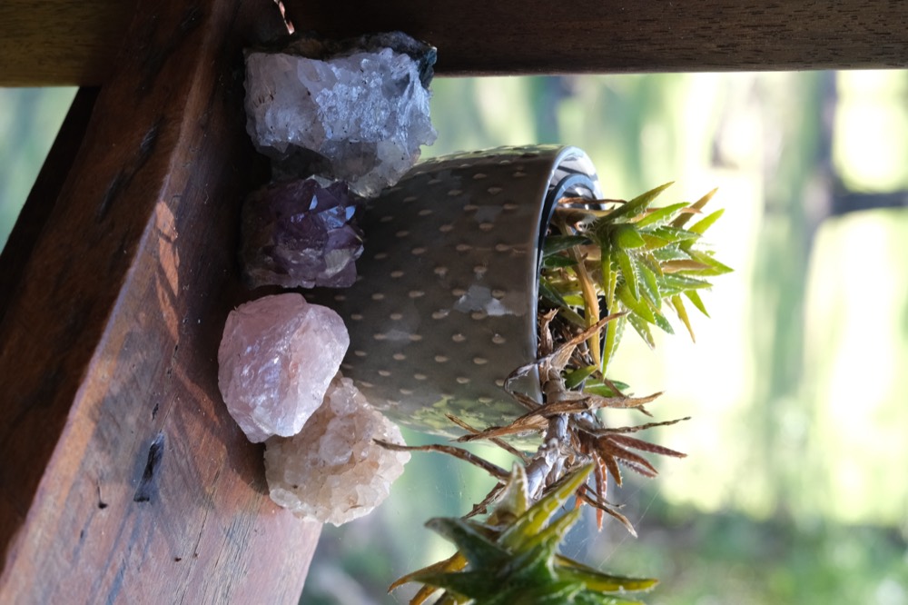 Crystals resting on a timber beam with greenery behind