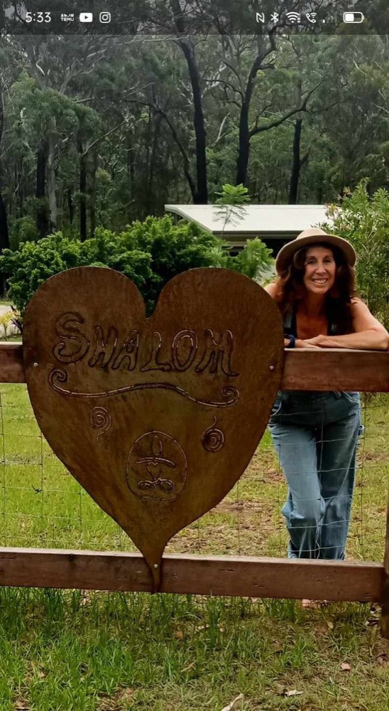 Mez beside the Shalom heart sign in the garden