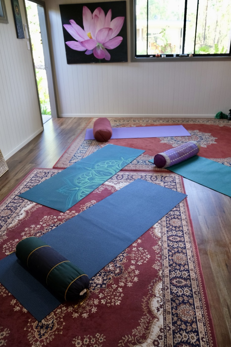 The yoga studio at Shalom with mats laid out and windows opening to the bush